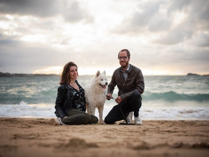 Portrait de famille à la plage avec un samoyède